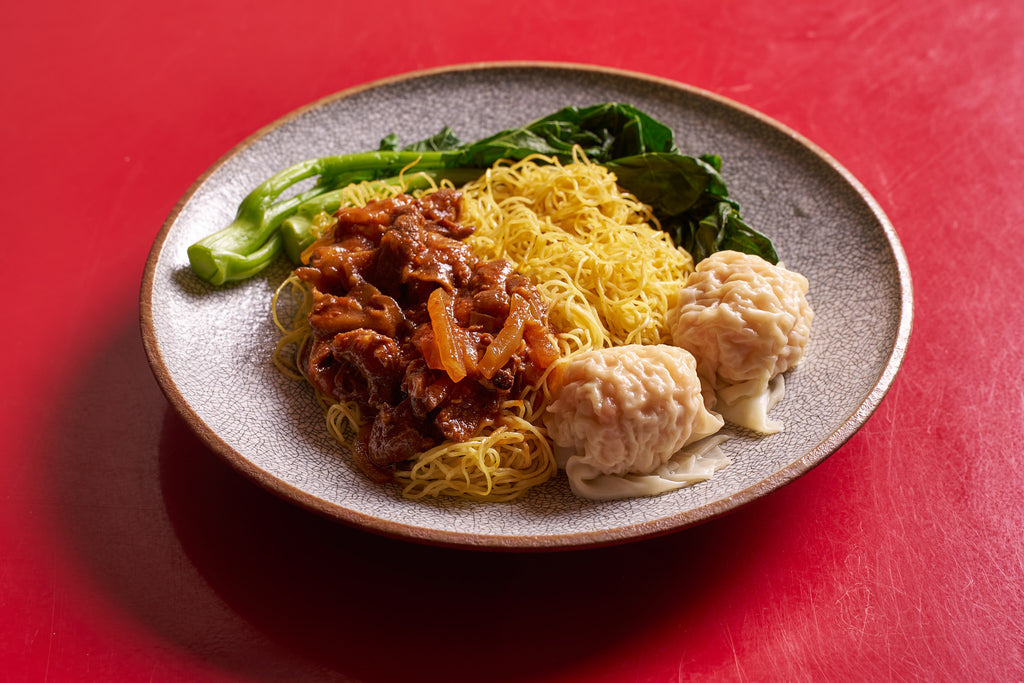 Dish of wontons, noodles with sauce, and Chinese broccoli